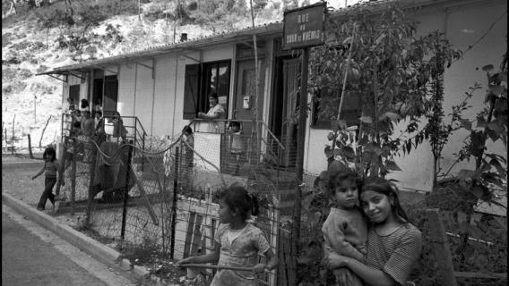 Vue d'une rue et de bâtiments devant lesquels jouent des enfants. Camp de Harkis de Cucuron, Vaucluse, France - 1975