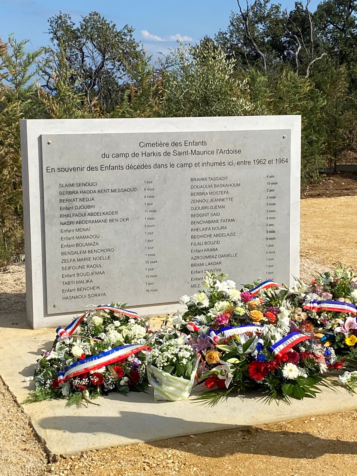 Dépôt de gerbes devant la stèle commémorative du cimetière pour enfants de Saint-Maurice-L'Ardoise