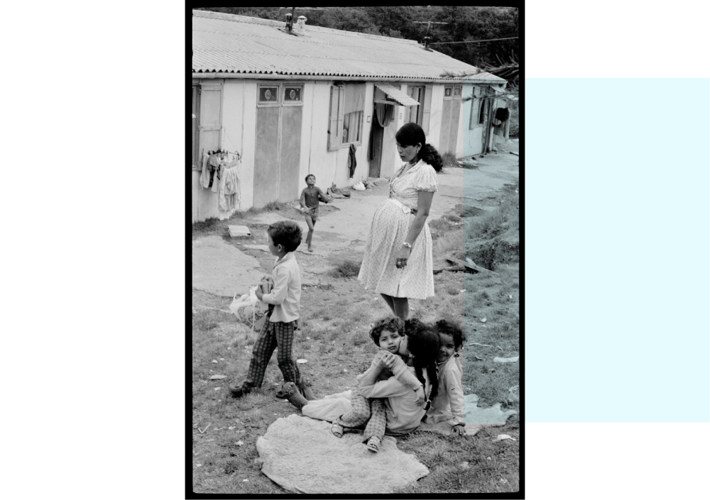 Une femme enceinte et des enfants qui jouent devant une maison dans un camp de Harkis, 1975, ville d’Apt (Vaucluse)