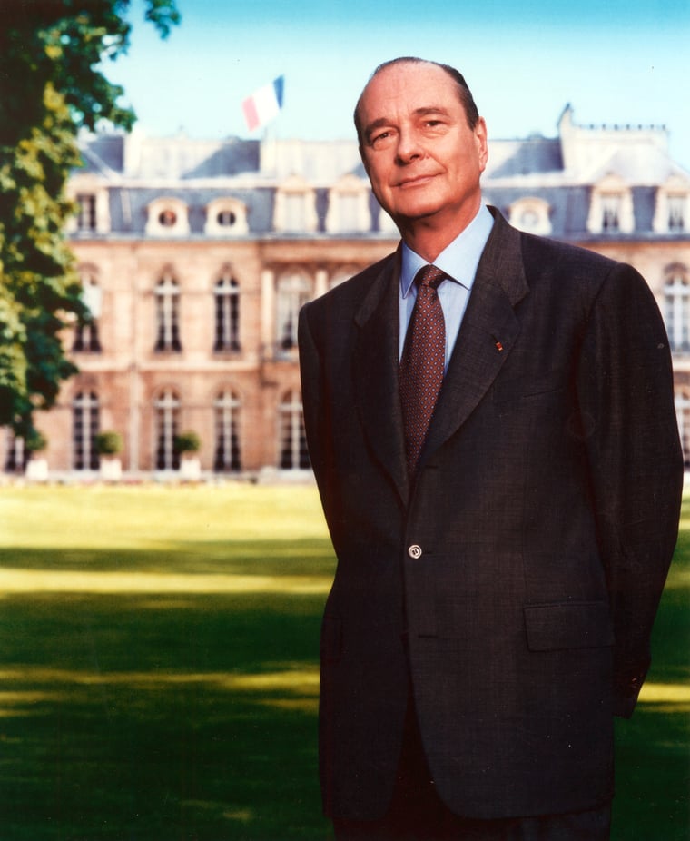 Vue officielle du Président de la République Jacques Chirac posant dans les jardins de l'Elysée que l'on aperçoit en arrière-plan.