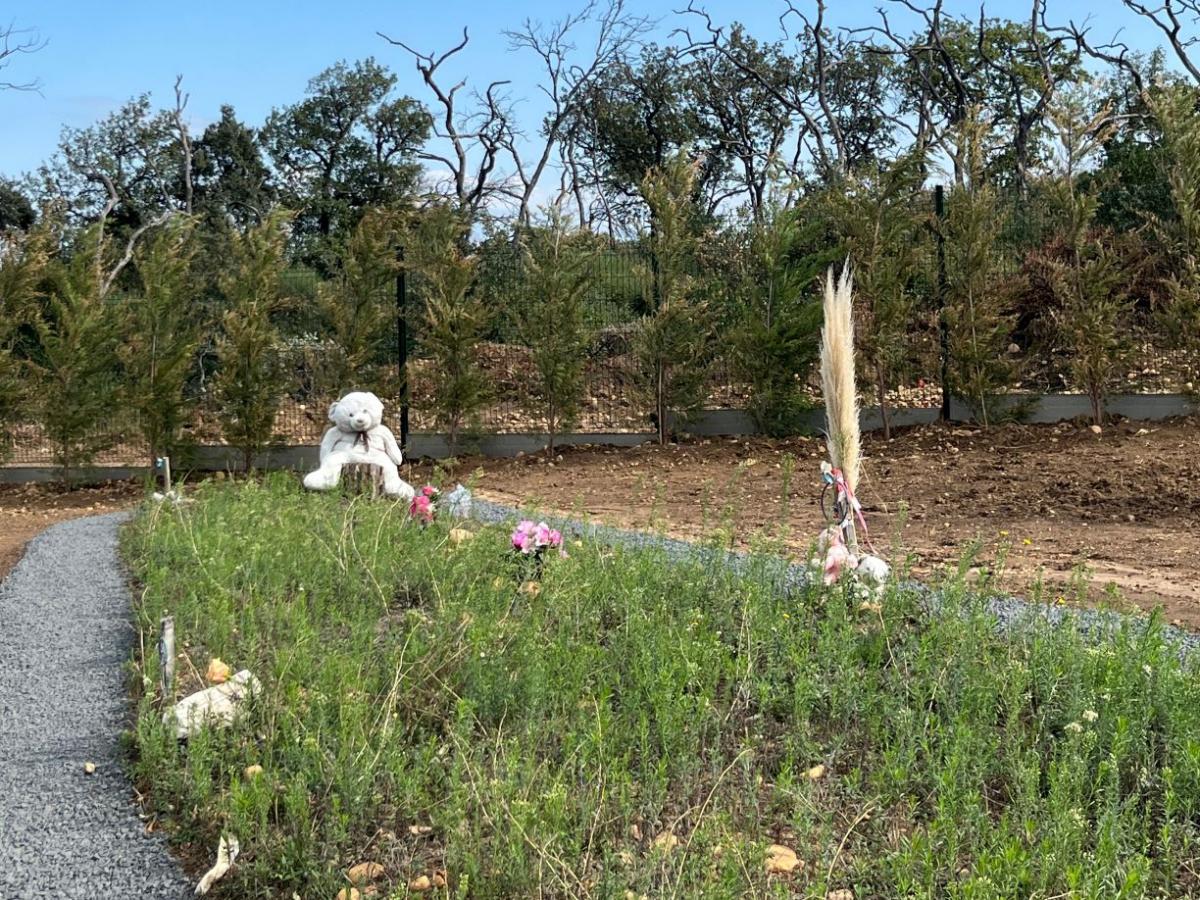 Vue du cimetière pour enfants de Saint-Maurice-L'Ardoise. Des peluches et des fleurs ont été déposées en mémoire des enfants.