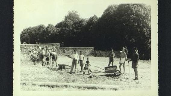 Enfants du hameau et du village effectuant ensemble des travaux de terrassement pour installer un terrain de volley-ball. 